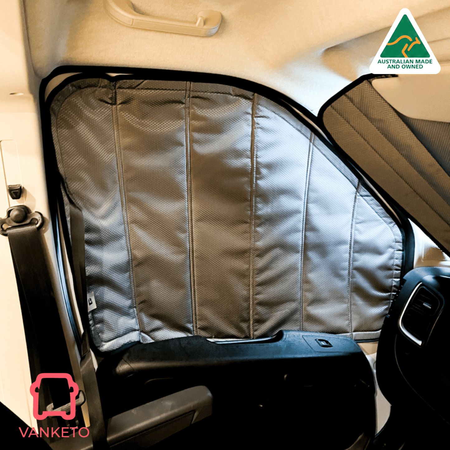 A gray Vanketo vehicle window shade installed on a car door, shown in a real vehicle interior with the steering wheel and dashboard visible. A Vanketo logo appears in the bottom-left corner, and an Australian Made and Vanketo badge appears in the top-right.