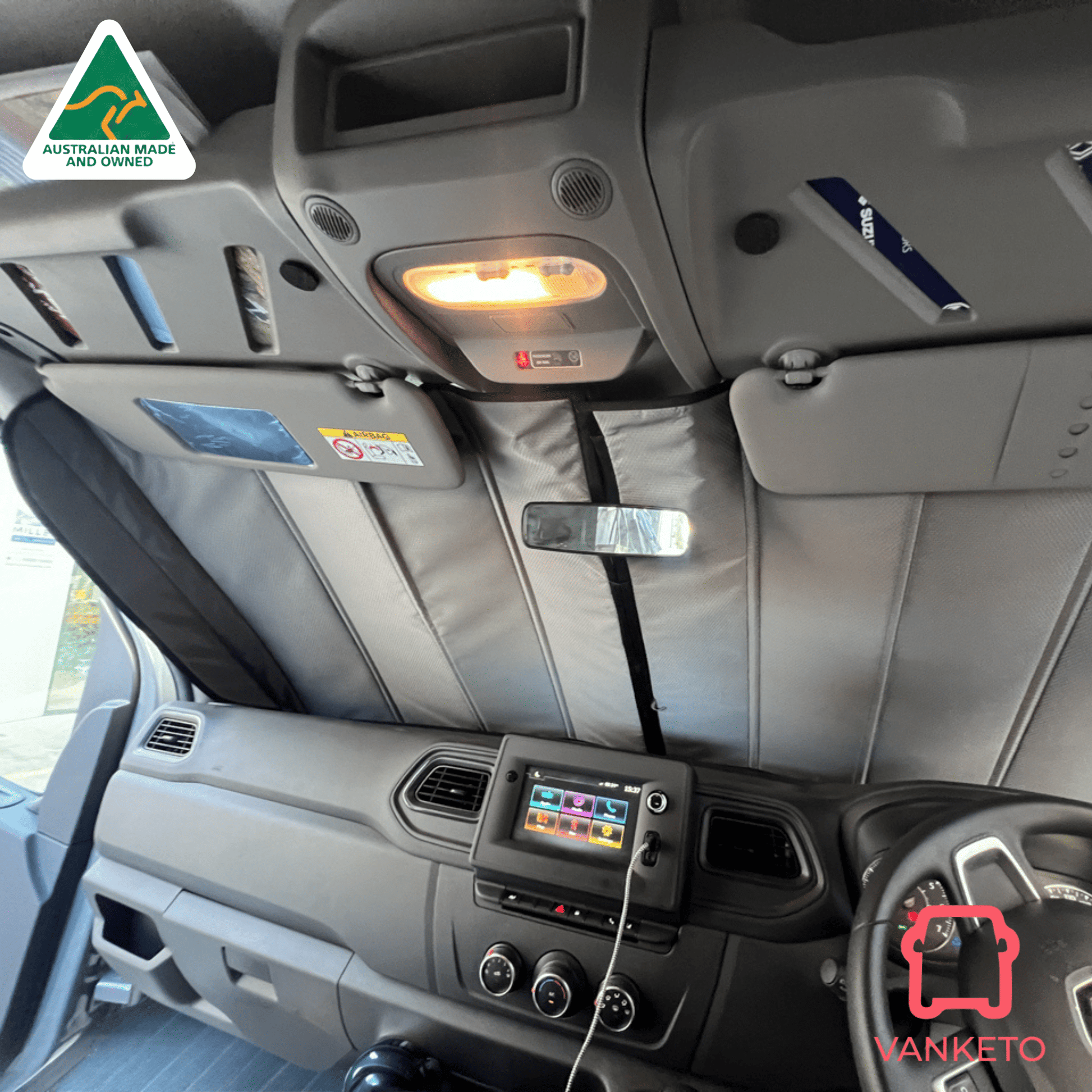 Gray fabric sunshade panels installed on the windshield and sun visors inside a vehicle cabin, shown with the vehicle's dashboard and steering wheel visible.