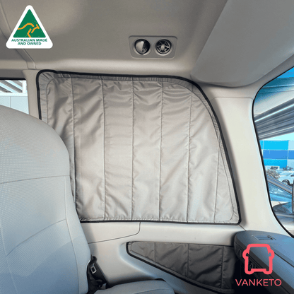 A light gray quilted car window shade installed on the rear side window of a vehicle cabin, shown with the front seat and interior door panel visible. Brand logos for Vanketo and Australian Made and Varnished are displayed on the image.